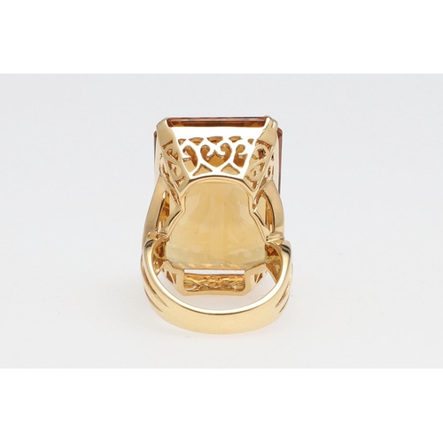 1143 - A LARGE CITRINE DRESS RING. The 18ct gold ring set with a  large rectangular citrine in pierced gall... 