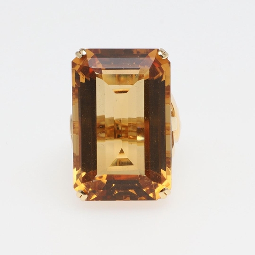 1143 - A LARGE CITRINE DRESS RING. The 18ct gold ring set with a  large rectangular citrine in pierced gall... 