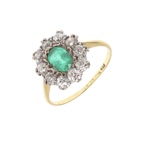 1144 - AN EMERALD AND DIAMOND CLUSTER RING. the oval-shaped emerald is set within a surround of circular ol... 