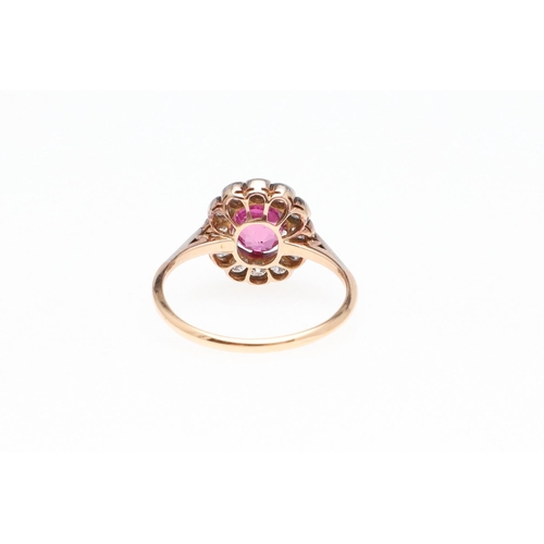 1145 - A PINK SAPPHIRE AND DIAMOND CLUSTER RING. the cushion-shaped pink sapphire is set within a surround ... 