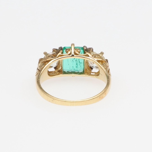 1151 - A COLOMBIAN EMERALD AND DIAMOND THREE STONE RING. the rectangular-shaped emerald is set with two cus... 