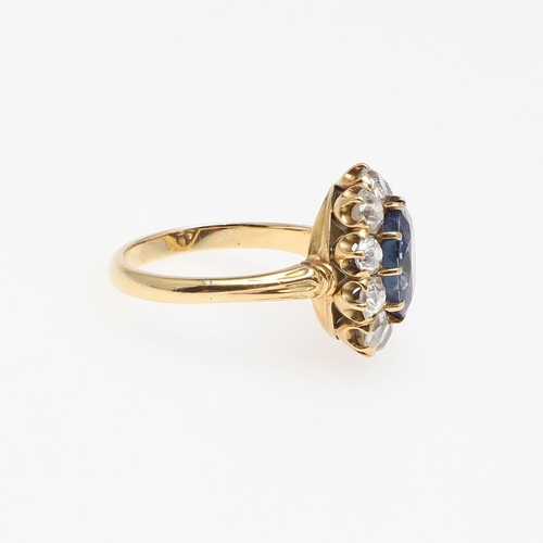 1153 - A SAPPHIRE AND DIAMOND CLUSTER RING. the oval-shaped sapphire weighs approximately 4.40 carats and i... 