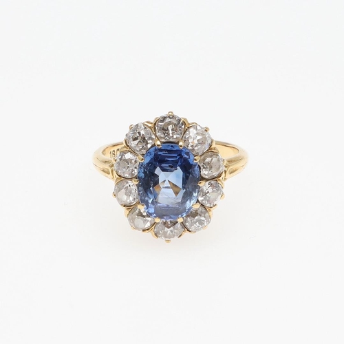 1153 - A SAPPHIRE AND DIAMOND CLUSTER RING. the oval-shaped sapphire weighs approximately 4.40 carats and i... 