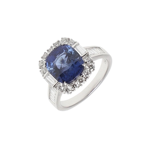 1154 - A SAPPHIRE AND DIAMOND CLUSTER RING. the oval-shaped sapphire weighs 5.22 carats and is set within a... 