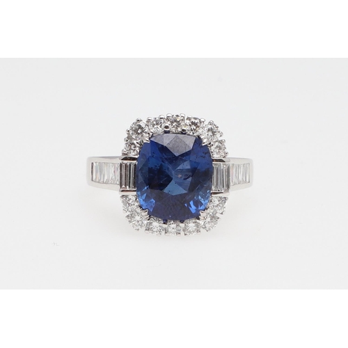 1154 - A SAPPHIRE AND DIAMOND CLUSTER RING. the oval-shaped sapphire weighs 5.22 carats and is set within a... 