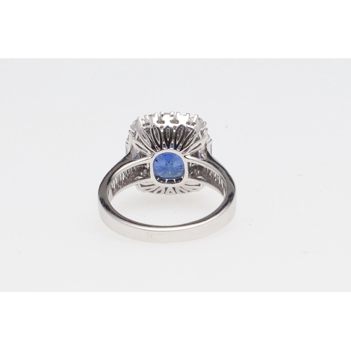 1154 - A SAPPHIRE AND DIAMOND CLUSTER RING. the oval-shaped sapphire weighs 5.22 carats and is set within a... 