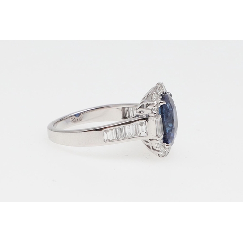 1154 - A SAPPHIRE AND DIAMOND CLUSTER RING. the oval-shaped sapphire weighs 5.22 carats and is set within a... 