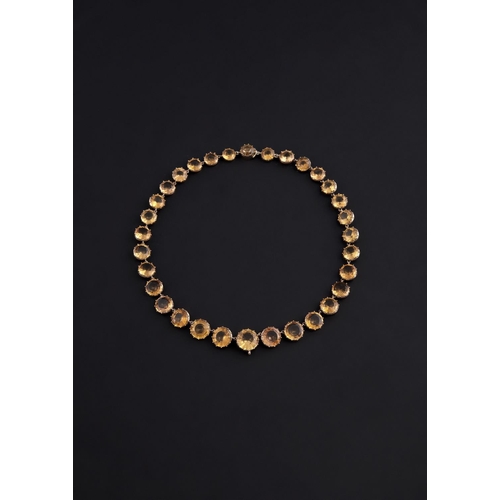 1165 - AN EARLY NINETEENTH CENTURY TOPAZ RIVIÈRE NECKLACE. formed with graduated circular-cut topazes in go... 