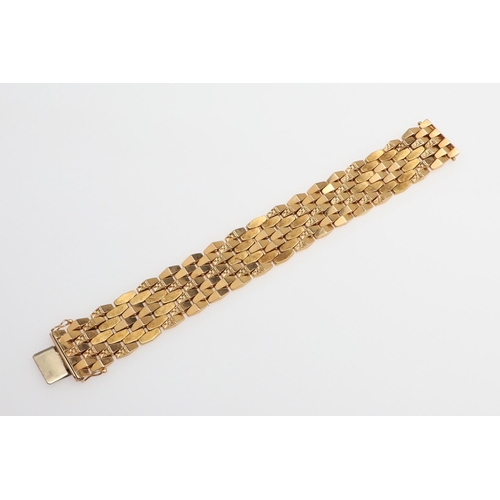 865 - AN 18CT GOLD PANEL BRACELET. formed with undulating plain and foliate engraved links to a concealed ... 