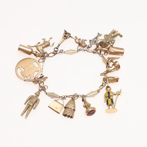 884 - A 9CT GOLD FANCY LINK CHARM BRACELET. with many assorted 9ct gold charms, 20cm long, 63.9 grams.  *C... 