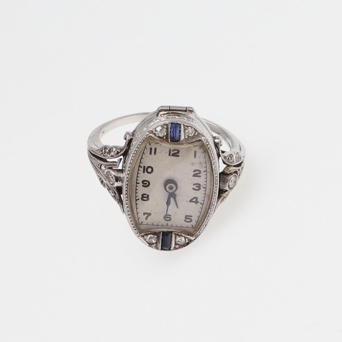 963 - A SAPPHIRE AND DIAMOND COCKTAIL WATCH RING. the oval dial with Arabic numerals, calibre-cut sapphire... 