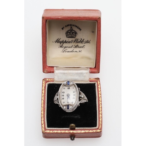 963 - A SAPPHIRE AND DIAMOND COCKTAIL WATCH RING. the oval dial with Arabic numerals, calibre-cut sapphire... 