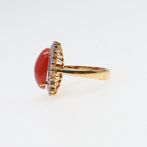 977 - A CORAL AND DIAMOND CLUSTER RING. the oval-shaped cabochon coral is set within a surround of circula... 