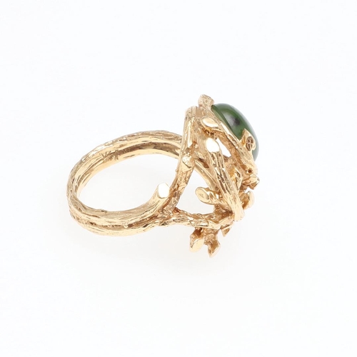 985 - A JADE AND GOLD DRESS RING. the 14ct gold openwork textured mount is set with an oval-shaped section... 