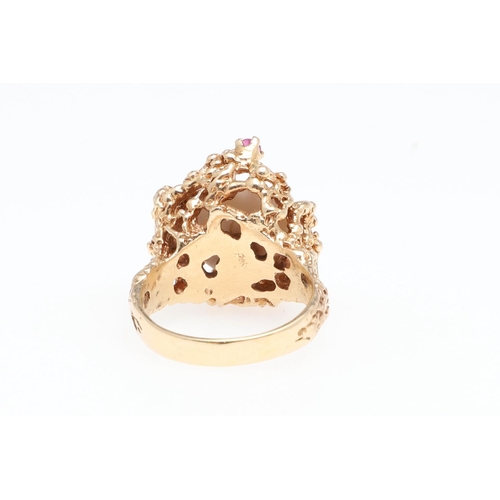 988 - A CULTURED PEARL, RUBY AND GOLD DRESS RING. the cultured pearl is set within a 14ct gold openwork te... 