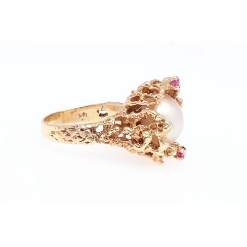 988 - A CULTURED PEARL, RUBY AND GOLD DRESS RING. the cultured pearl is set within a 14ct gold openwork te... 