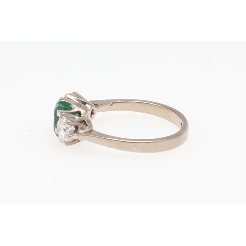 993 - AN EMERALD AND DIAMOND THREE STONE RING. the rectangular-shaped emerald  is set with two brilliant-c... 