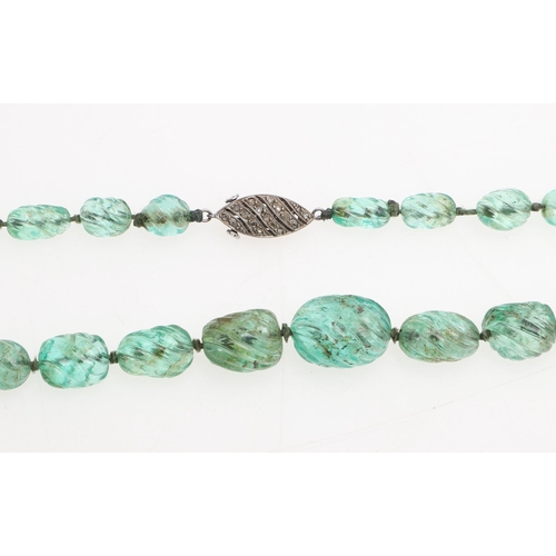 998 - A SINGLE ROW GRADUATED EMERALD BEAD NECKLACE. mounted with carved irreqular-shaped emerald beads, to... 