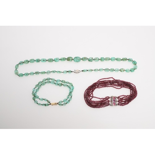 998 - A SINGLE ROW GRADUATED EMERALD BEAD NECKLACE. mounted with carved irreqular-shaped emerald beads, to... 