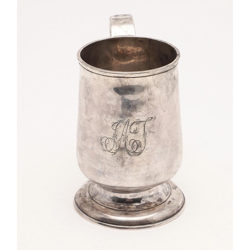 124 - A GEORGE III NORTH-COUNTRY PROVINCIAL MUG. baluster form, with a scroll handle and on a spreading ci... 