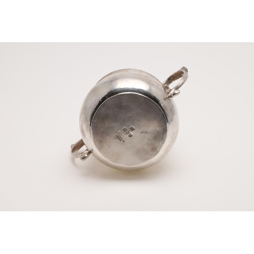 126 - AN EARLY 20TH CENTURY PORRINGER. with twin scroll handles and the bellied body with a hammered finis... 