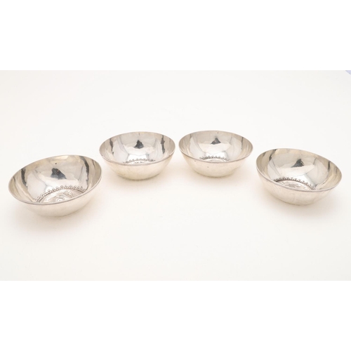 129 - A SET OF FOUR CONTINENTAL BOWLS. circular form, with incised borders, embossed domed centres and pun... 