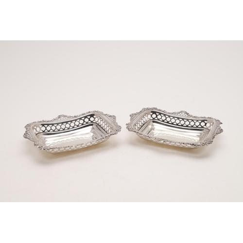 131 - A PAIR OF LATE VICTORIAN BONBON DISHES. rectangular form, with pierced sides and foliate scroll bord... 