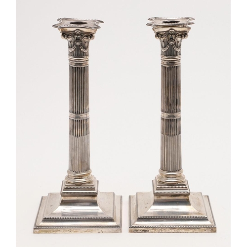 149 - A PAIR OF VICTORIAN CANDLESTICKS. on bevelled square bases (loaded), with fluted columns, bead borde... 