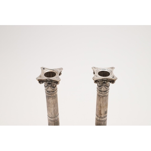 149 - A PAIR OF VICTORIAN CANDLESTICKS. on bevelled square bases (loaded), with fluted columns, bead borde... 