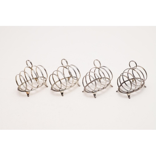 157 - AN EARLY 20TH CENTURY CASED SET OF FOUR SMALL TOAST RACKS. oval outline, with five loop supports, a ... 