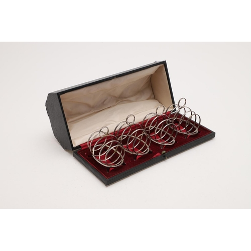 157 - AN EARLY 20TH CENTURY CASED SET OF FOUR SMALL TOAST RACKS. oval outline, with five loop supports, a ... 