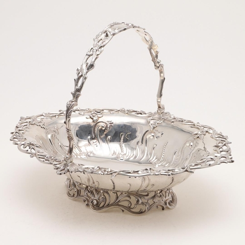 173 - A VICTORIAN SWING-HANDLED CAKE BASKET. shaped oval outline, with repoussÃ© decoration in the centre ... 