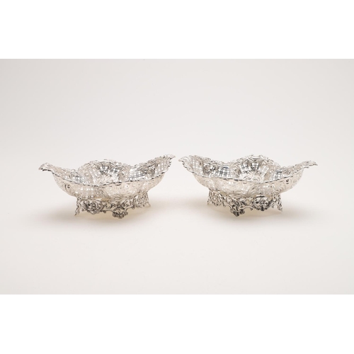 181 - A PAIR OF EDWARDIAN BASKETS. shaped oval outline, with pierced sides, a foliate scrolling border and... 