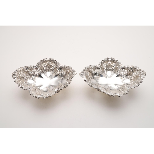 181 - A PAIR OF EDWARDIAN BASKETS. shaped oval outline, with pierced sides, a foliate scrolling border and... 