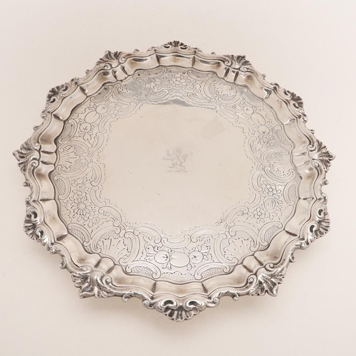 195 - A GEORGE II SALVER. of shaped circular outline, with a husk & scroll border, chased decoration in th... 