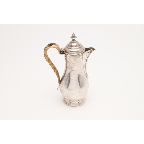 210 - A GEORGE III HOT WATER JUG. baluster form, with a cane insulated handle and an urn finial, by Peter ... 