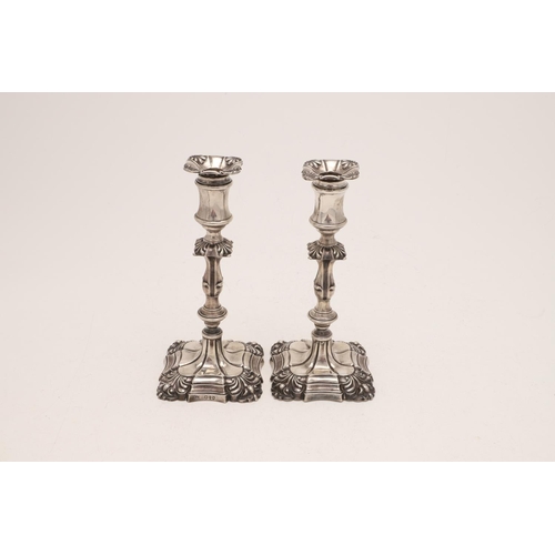 215 - A PAIR OF VICTORIAN CANDLESTICKS. with shaped square bases (loaded), shell corners, knopped stems & ... 