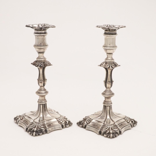 216 - A PAIR OF VICTORIAN CANDLESTICKS. on shaped square bases (loaded), with shell corners, knopped stems... 