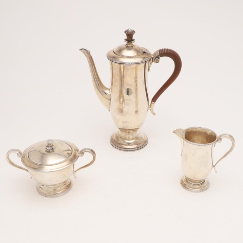 250 - A 20TH CENTURY THREE-PIECE COFFEE SET. of waisted form, with scroll handles, circular feet and appli... 