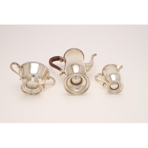 250 - A 20TH CENTURY THREE-PIECE COFFEE SET. of waisted form, with scroll handles, circular feet and appli... 