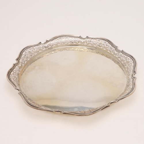 251 - A MID-20TH CENTURY TRAY OR SALVER. shallow shaped circular form, with a pierced gallery, a moulded b... 