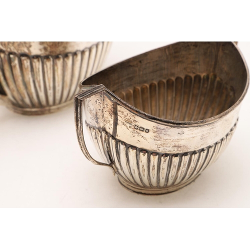 277 - A GEORGE V THREE-PIECE TEA SET. oval form, with fluted lower bodies & angular handles, by Goldsmiths... 