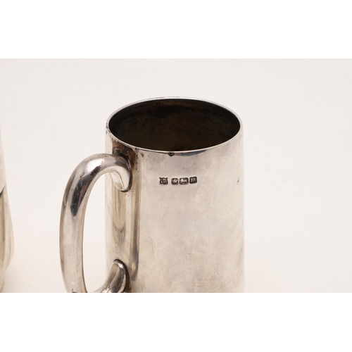 280 - TWO 20TH CENTURY SILVER MUGS. one with a fluted lower body and a collet foot, by William Hutton & So... 