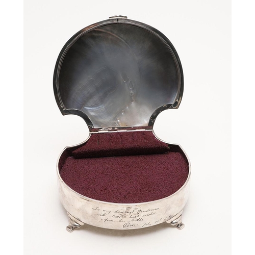 316 - A GEORGE V DRESSING TABLE BOX. shell-shaped, the cover inset with mother-of-pearl and raised on four... 