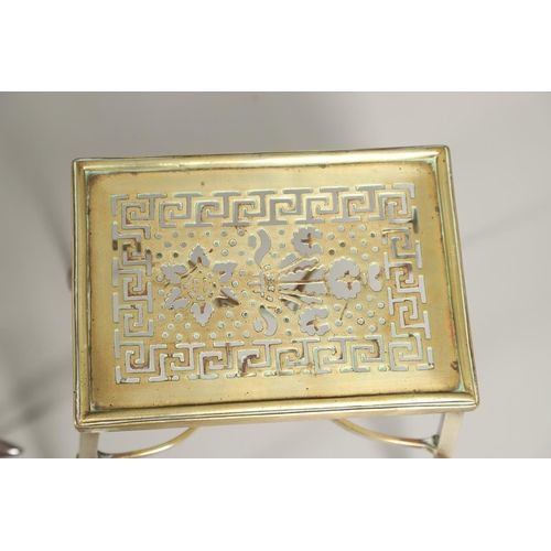 1456 - A REGENCY BRASS TRIVET. the top with ornate pierced Greek key and circle pattern on slender legs joi... 