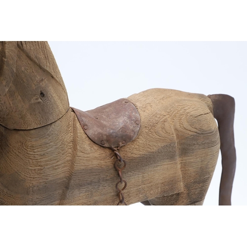 1463 - A CARVED WOODEN TOY ROCKING HORSE. with metal saddle and tail upon a metal rocker, height 44cm, widt... 