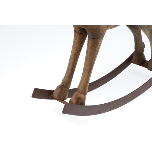 1463 - A CARVED WOODEN TOY ROCKING HORSE. with metal saddle and tail upon a metal rocker, height 44cm, widt... 