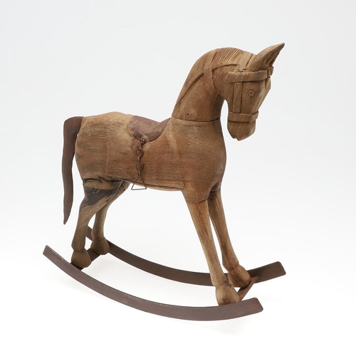 1463 - A CARVED WOODEN TOY ROCKING HORSE. with metal saddle and tail upon a metal rocker, height 44cm, widt... 