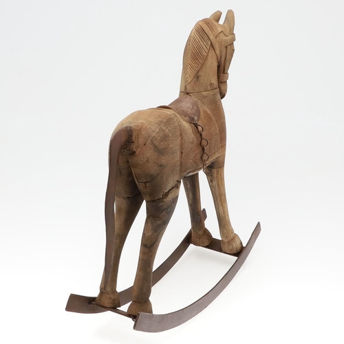 1463 - A CARVED WOODEN TOY ROCKING HORSE. with metal saddle and tail upon a metal rocker, height 44cm, widt... 