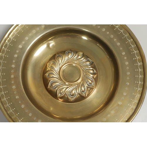 1467 - A LARGE 19TH CENTURY BRASS ALMS DISH. the centre with raised boss and repousse work, the surround wi... 